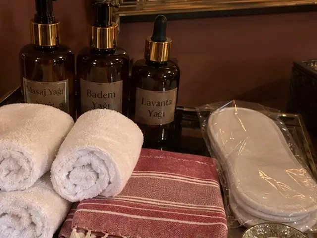 Masaj yağları, rulo havlular, kırmızı çizgili peştemal ve terlik — Zekeriyaköy, Masaj Salonun